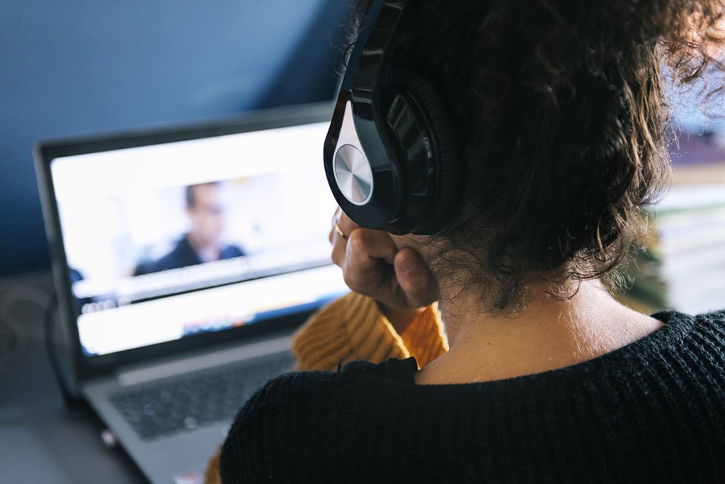 female translator at work on laptop with headphones on